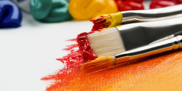 Artist painting in a studio with colorful canvases