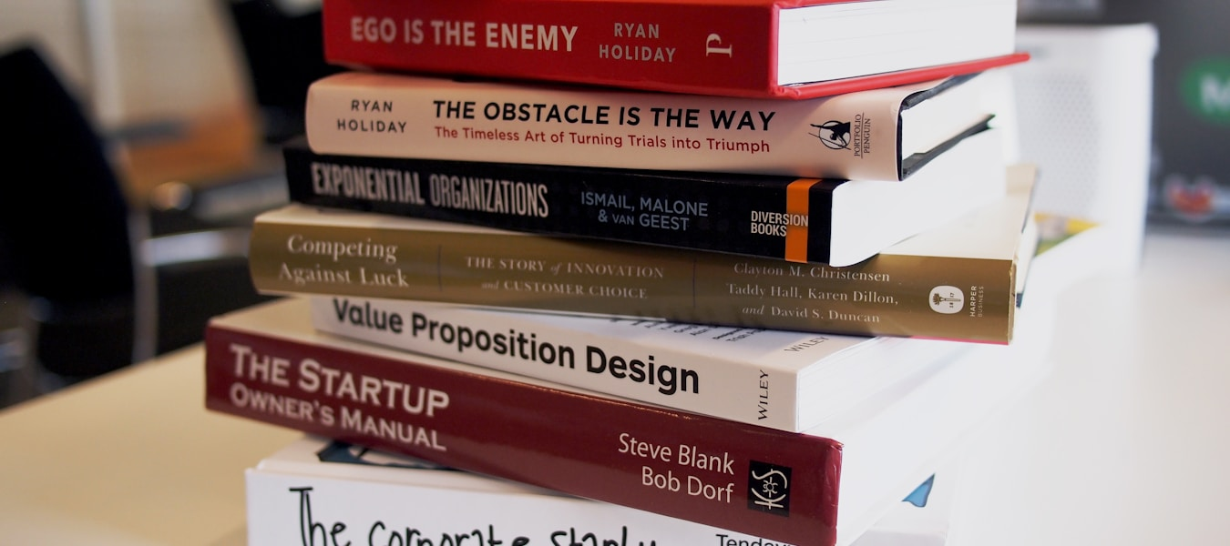 Stack of colorful children's books on a wooden surface